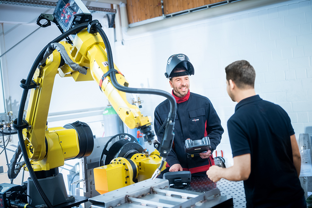 EWM robotic welding cell with red six-axis robot and welding power source